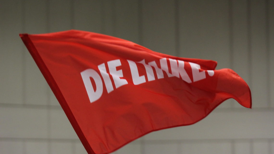weißes Die Linke Logo auf einer roten Flagge